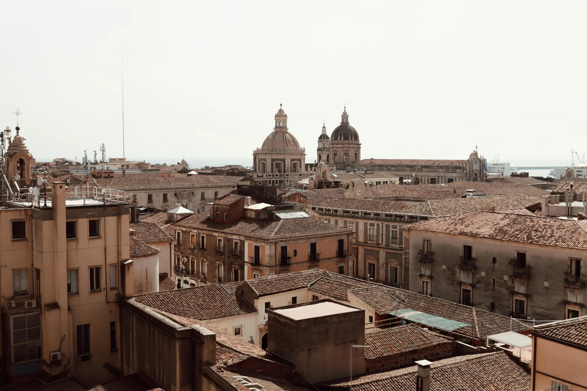 Vista panoramica di tetti barocchi e cupole che si stagliano maestose nel centro storico di Catania, città della Sicilia.